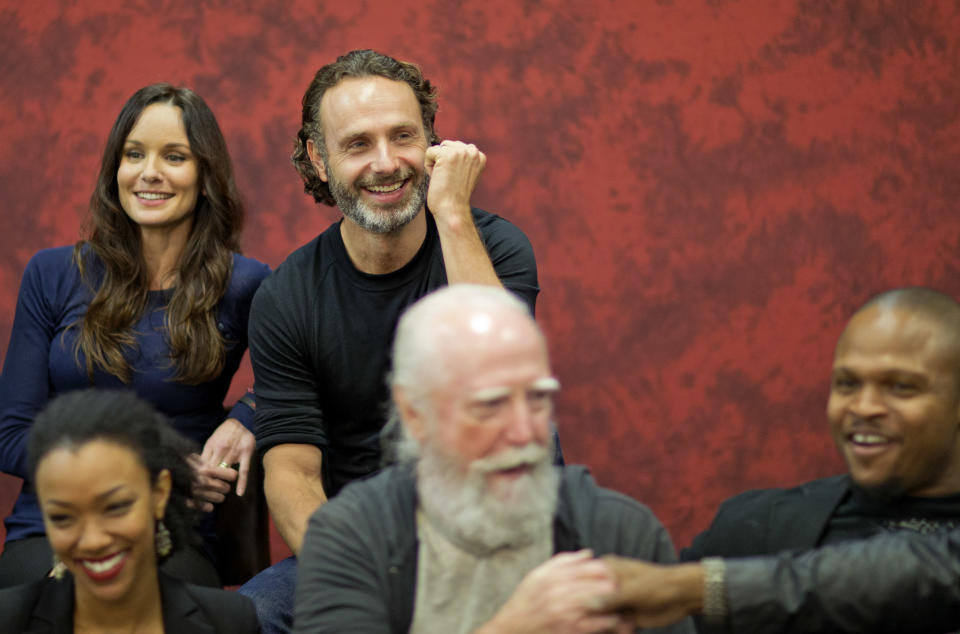 Andrew Lincoln, top right, who plays Rick Grimes on the cable TV show "The Walking Dead," sits for a photo with fellow cast members at Walker Stalker Con, a convention based off the show, Saturday, Nov. 2, 2013, in Atlanta. For Lincoln, acting out the battle scenes in downtown Atlanta during the first season of “The Walking Dead” was a joyous time. Here was the British actor, on the same streets where Confederate forces battled Union troops in the American Civil War, shooting his way through a foreboding urban landscape now over-run by flesh-devouring “walkers.” “It was one of the greatest weekends of my career, you know,” he says, his eyes lighting up with excitement. “We shut down four blocks of downtown Atlanta and I get to ride into the city on a horse. It was epic. (AP Photo/David Goldman)