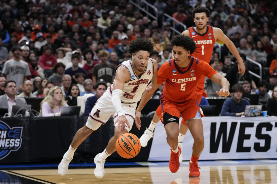 Alabama guard Mark Sears (1) dribbles past Clemson forward Jack Clark (5) during the second half of an Elite 8 college basketball game in the NCAA tournament Saturday, March 30, 2024, in Los Angeles. (AP Photo/Ashley Landis)