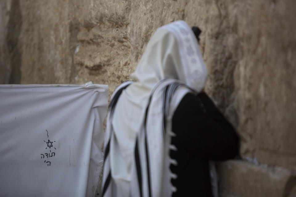 An ultra-Orthodox Jewish man prays ahead of the Jewish new year at the Western Wall, the holiest site where Jews can pray in Jerusalem's old city, Wednesday, Sept. 16, 2020. A raging coronavirus outbreak is casting a shadow over the normally festive Jewish New Year. With health officials recommending a nationwide lockdown, traditional family gatherings will be muted, synagogue prayers will be limited to small groups and roads will be empty. (AP Photo/Sebastian Scheiner)