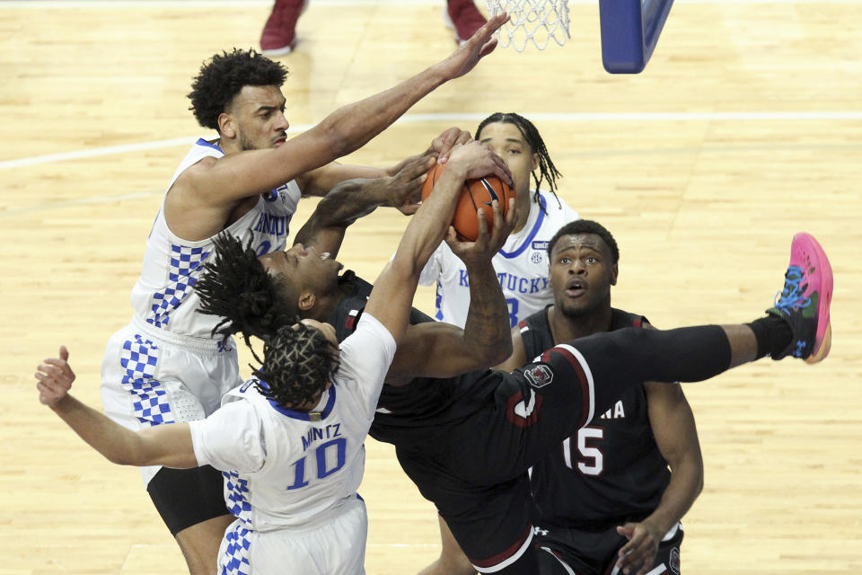 South Carolina's Trae Hannibal, center, has his shot blocked by Kentucky's Davion Mintz (10) and Olivier Sarr, top left, during the first half of an NCAA college basketball game in Lexington, Ky., Saturday, March 6, 2021. (AP Photo/James Crisp)