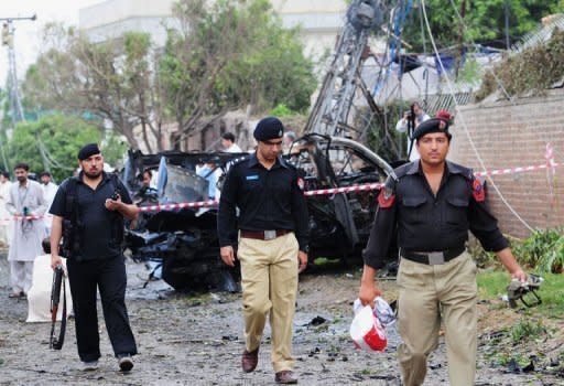 Pakistani policemen collect evidence at a bomb blast site in Peshawar. A suicide car bomber rammed a US consulate vehicle in Pakistan on Monday, killing at least two people in the deadliest attack targeting Americans in the country in more than two years