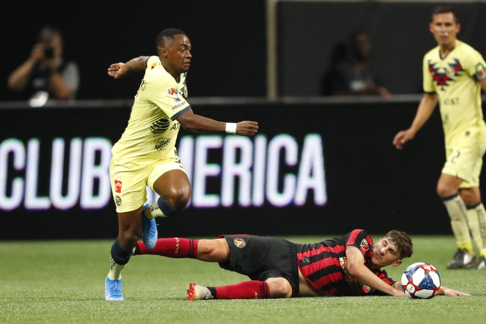 Atlanta United's Emerson Hyndman has the ball kicked away by Club America midfielder Renato Ibarra, left, during the first half of a Campeones Cup soccer match Wednesday, Aug. 14, 2019, in Atlanta. (AP Photo/John Bazemore)