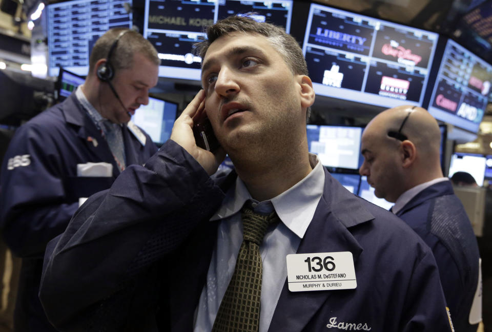 Trader Nicholas DeStafano, center, works on the floor of the New York Stock Exchange Wednesday, Feb. 5, 2014. The U.S. stock market is edging lower in early trading after a modest recovery the day before. (AP Photo/Richard Drew)