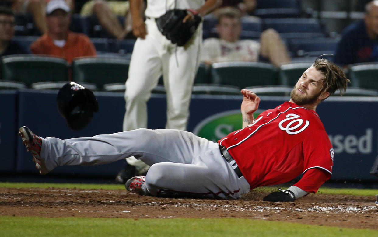 Washington Nationals left fielder Bryce Harper (34) scores on a Kevin Frandsen double in the eleventh inning of a baseball game against the Atlanta Braves Sunday, Aug. 10, 2014 in Atlanta. Nationals won 4-1.(AP Photo/John Bazemore)