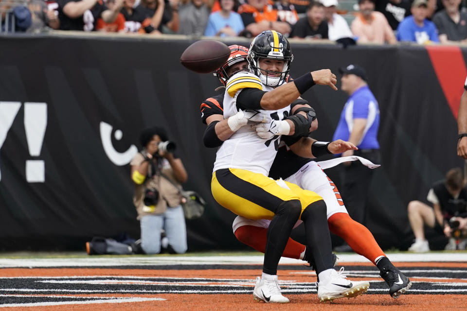 Pittsburgh Steelers quarterback Mitch Trubisky (10), front, is pressured by Cincinnati Bengals defensive end Sam Hubbard, back,as he throws during the second half of an NFL football game, Sunday, Sept. 11, 2022, in Cincinnati. (AP Photo/Jeff Dean)