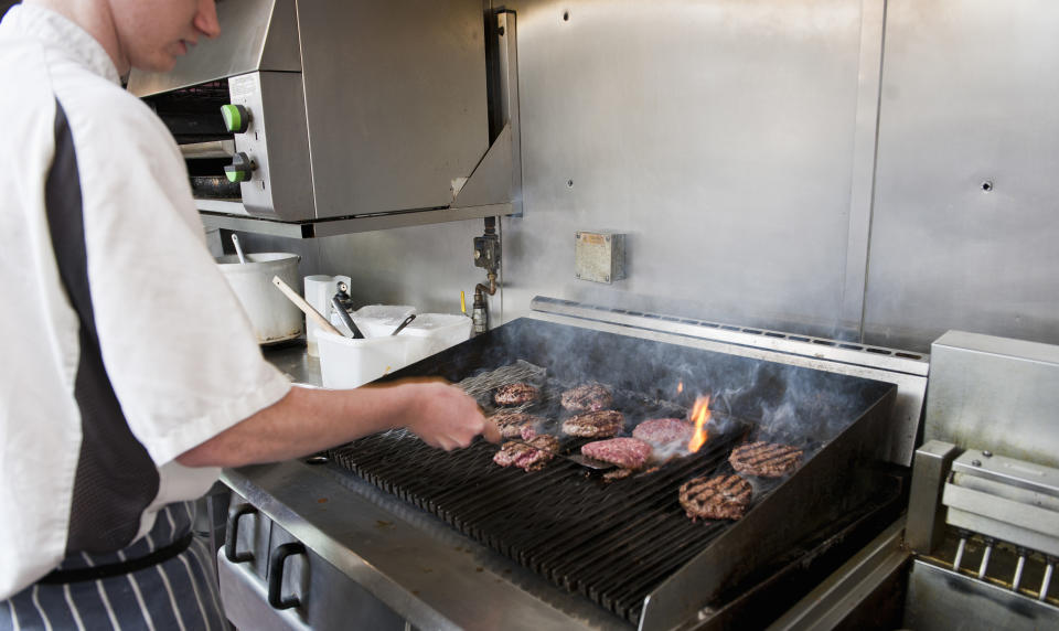 Fast-food worker flipping burgers