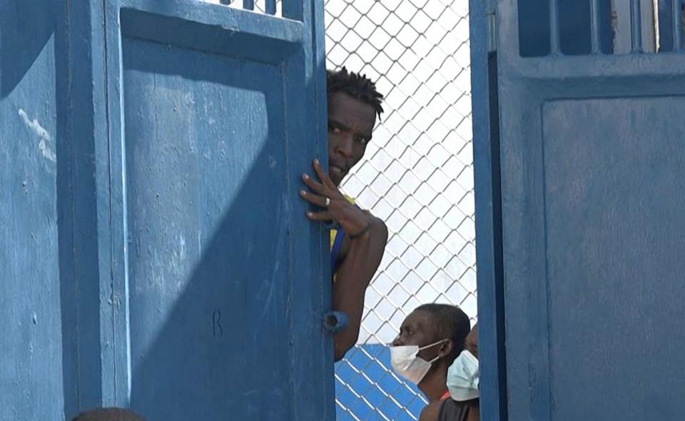 PHOTO: This screen grab taken from AFPTV shows a person looking out from behind a door near the National Penitentiary in Port-au-Prince, Haiti, on March 3, 2024, after armed gangs attacked the country's largest prison and freed scores of inmates. (Luckenson Jean/AFPTV/AFP via Getty Images)