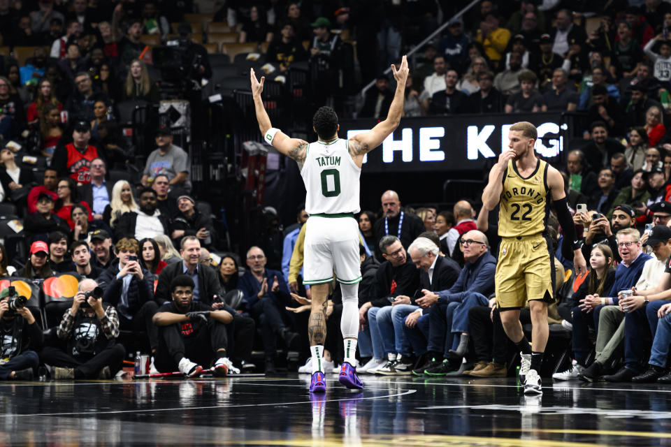 Boston Celtics forward Jayson Tatum (0) celebrates a 3-pointer, next to Toronto Raptors guard Malachi Flynn during the first half of an NBA basketball game Friday, Nov. 17, 2023, in Toronto. (Christopher Katsarov/The Canadian Press via AP)