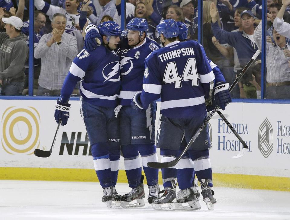 Tampa Bay Lightning center Steven Stamkos (91) celebrates with teammates Alex Killorn (17) and Nate Thompson (44) after scoring against the Montreal Canadiens during the third period of Game 1 of a first-round NHL hockey playoff series on Wednesday, April 16, 2014, in Tampa, Fla. (AP Photo/Chris O'Meara)