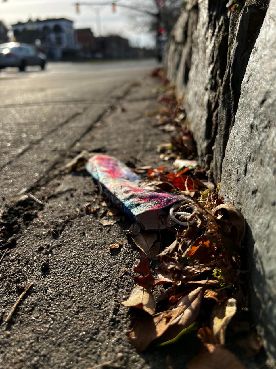 A disposable mask is discarded on the side of the road in Newport.