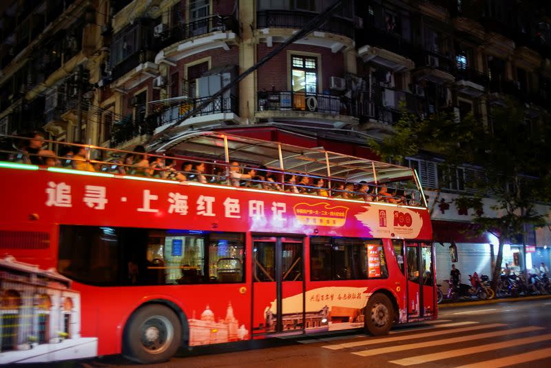 Tourists ride on a bus marking the 100th founding anniversary of the Communist Party of China, in Shanghai