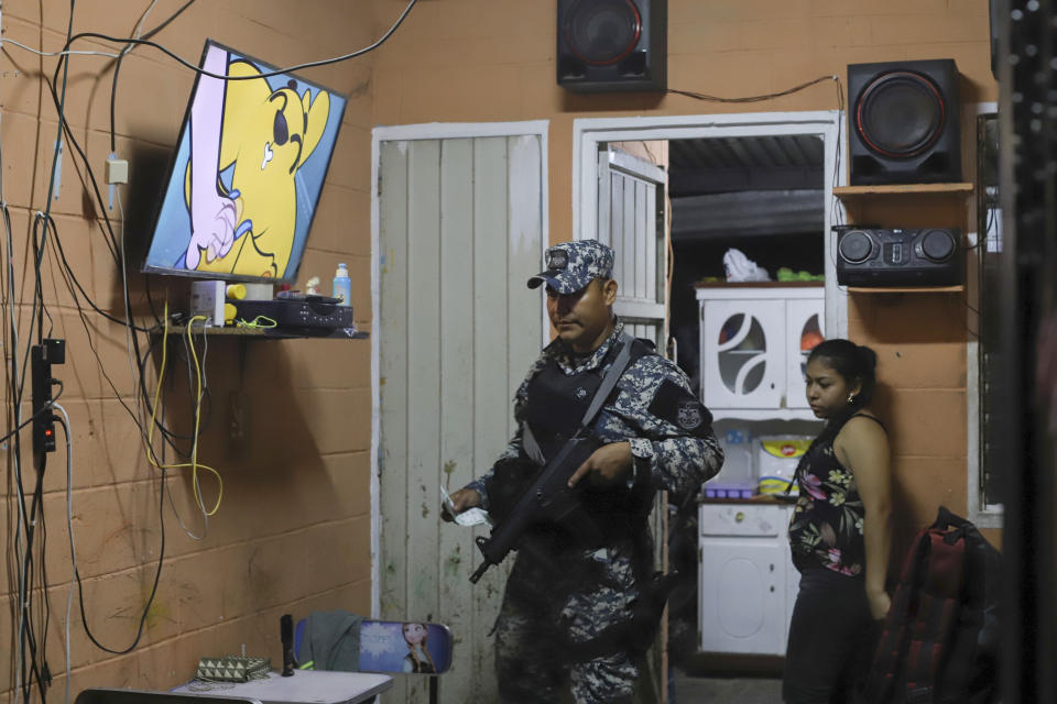 National Civil Police inspect the documentation of residents inside their home in Vista al Lago neighborhood, formerly under the control of the Mara Salvatrucha gang, in Ilopango, El Salvador, Thursday, March 2, 2023. El Salvador's congress has approved President Bukele's request to extend the period of special powers for another month, meaning the country will go at least a full year with some constitutional rights suspended in its fight against gangs. (AP Photo/Salvador Melendez)