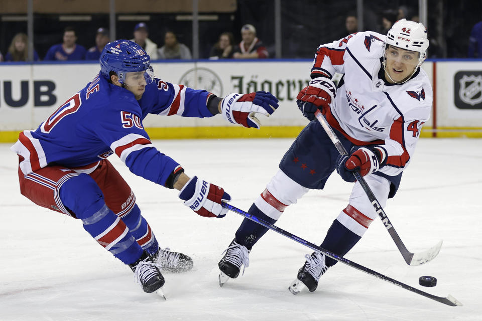 Washington Capitals defenseman Martin Fehervary (42) clears the puck past New York Rangers left wing Will Cuylle during the first period of an NHL hockey game Wednesday, Dec. 27, 2023, in New York. (AP Photo/Adam Hunger)