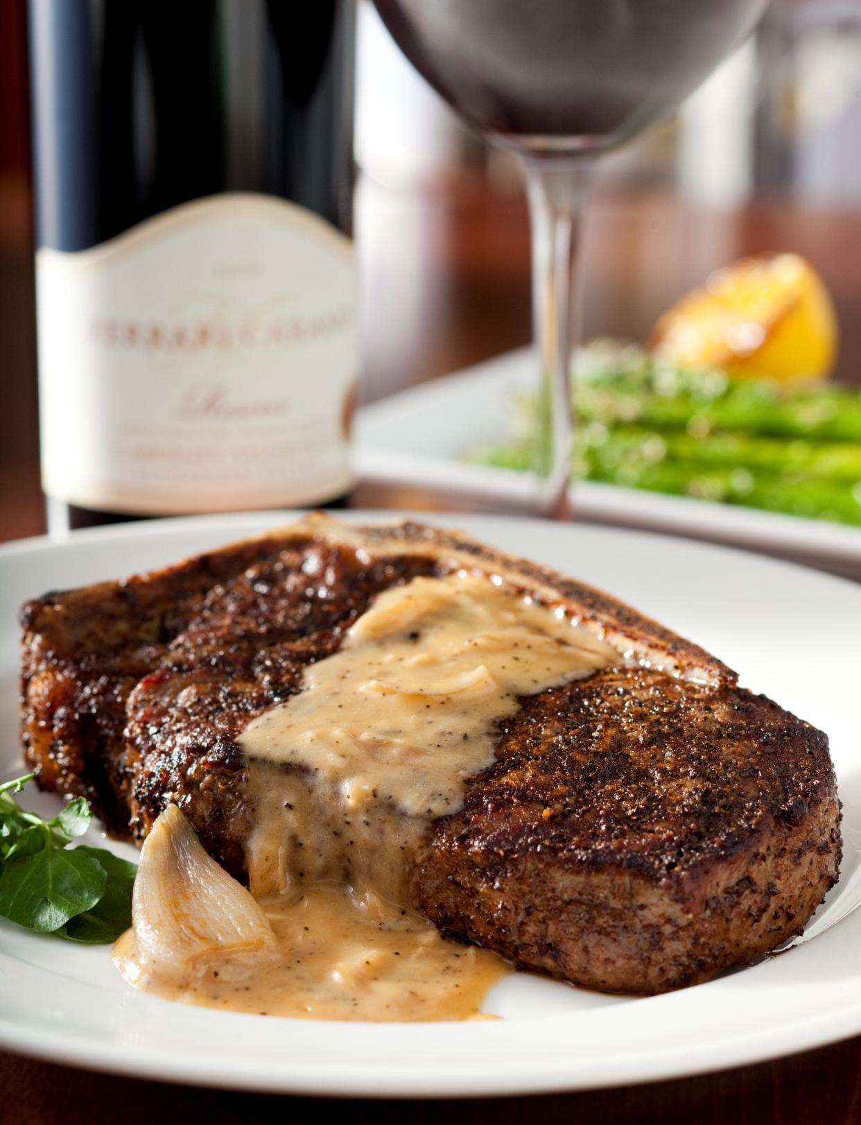The bone-in Kona-crusted dry-aged sirloin at the Capital Grille is topped with shallot butter.
