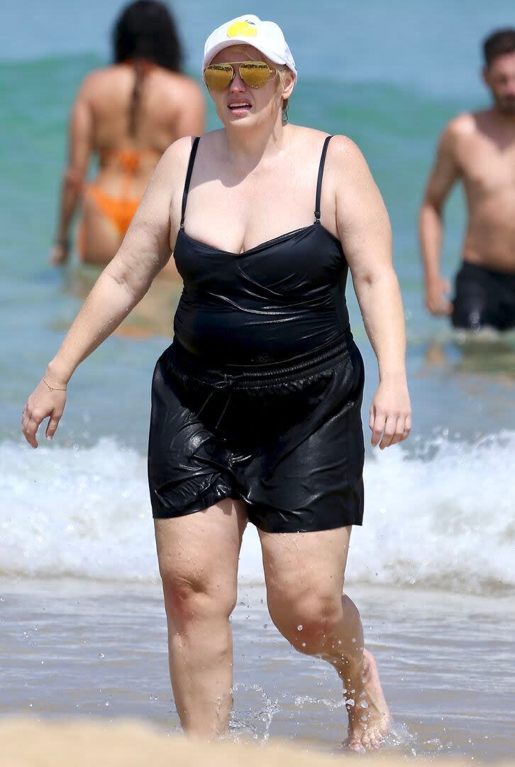 Rebel Wilson disfrutó de Bondi Beach con su pareja Ramona Agruma. La actriz australiana decidió aprovechar el día de calor para darse un chapuzón en el mar de una de las playas más famosas de Sídney. Para la ocasión, la actriz lució una malla enteriza negra y un short del mismo color, que combinó con lentes espejados amarillos y una gorra para protegerse del sol. Wilson se dejó ver despreocupada en la playa apenas unos días después de realizar un posteo en sus redes sociales para hablar, sin vueltas, de su reciente aumento de peso. 