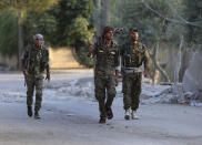 FILE -- In this June 22, 2017 file photo, U.S.-backed Syrian Democratic Forces fighters prepare to move against Islamic state group militants, in Raqqa, northeast Syria. Syria’s Kurds have been America’s partner in fighting the Islamic State group for nearly four years. Now they are furious over an abrupt U.S. troop pull-back that exposes them to a threatened attack by their nemesis, Turkey. The surprise U.S. pull-back from positions near the Turkish border, which began Monday, Oct. 7, 2019, stung even more because the Kurds have been abandoned before by the U.S. and other international allies on whose support they'd pinned their aspirations. (AP Photo/Hussein Malla, File)