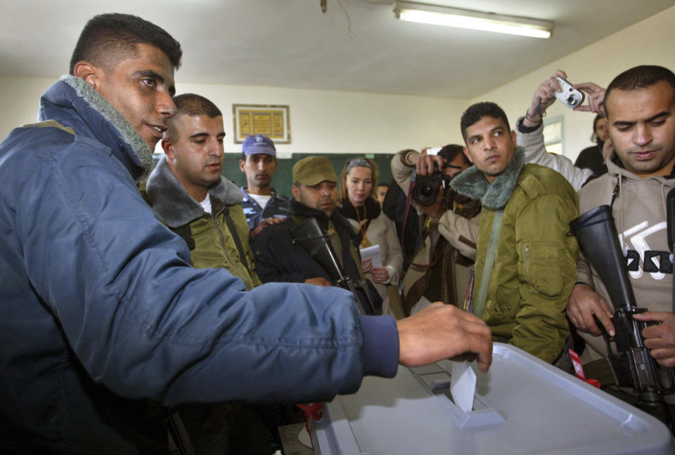 FILE - In this Jan. 9, 2005 file photo, Zakaria Zubeidi, then West Bank leader of Palestinian militant group Al Aqsa Martyrs Brigades votes during the Palestinian election, in the West Bank town of Jenin. For nearly two decades, Zubeidi has been an object of fascination for Israelis and Palestinians alike, who have seen his progression from a child actor to a swaggering militant, to the scarred face of a West Bank theater promoting “cultural resistance” to Israeli occupation. In his latest act, he has emerged as one of Israel's most wanted fugitives after tunneling out of a high-security prison on Monday, Sept. 6, 2021 with five other Palestinian militants. (AP Photo/Brennan Linsley)