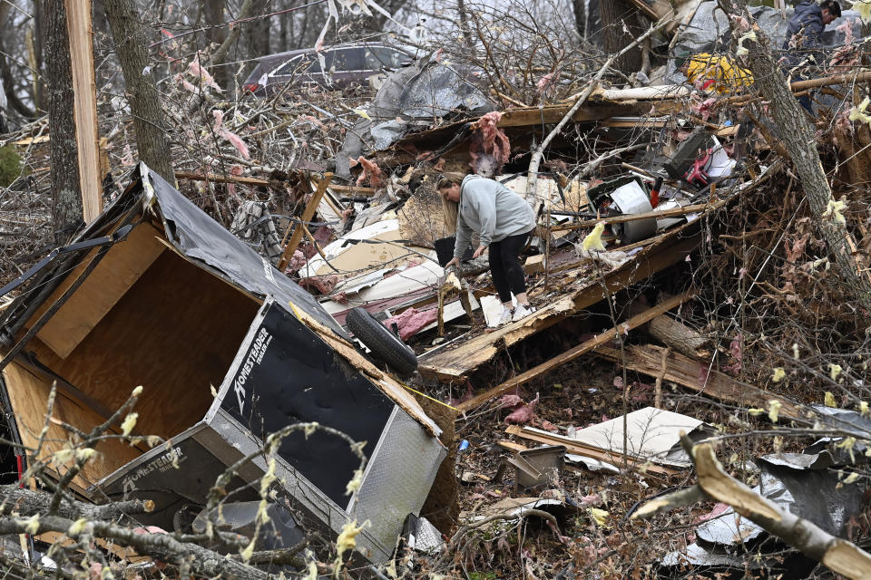 Cindy Smith searches for belongings in the rubble of her father's mobile home, Sunday, Dec. 10, 2023, in Clarksville, Tenn. Tornados caused catastrophic damage in Middle Tennessee on Saturday afternoon and evening, Dec. 9. (AP Photo/Mark Zaleski)