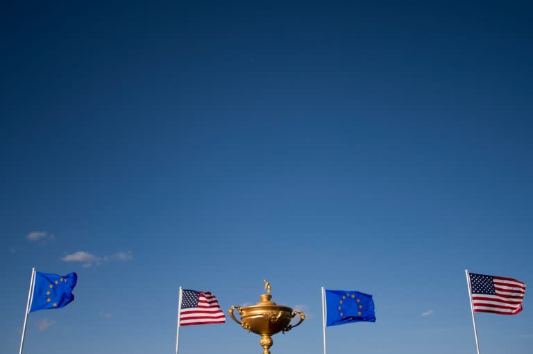 The European Union and American flags fly behind a statue of the Ryder Cup trophy at Hazeltine National Golf Course in Chaska, Minnesota