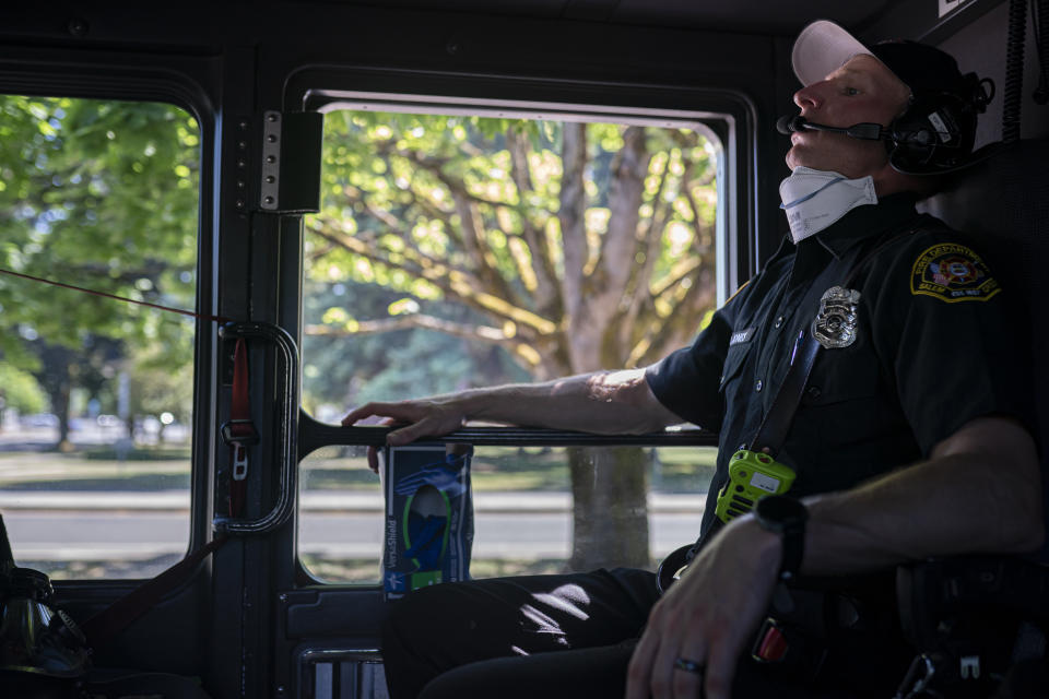 Salem Fire Department paramedic Justin Jones tries to stay cool after responding to a heat exposure call during a heat wave, Saturday, June 26, 2021, in Salem, Ore. (AP Photo/Nathan Howard)