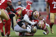 New Orleans Saints tight end Taysom Hill, second from bottom, is tackled by San Francisco 49ers defensive end Samson Ebukam, bottom, linebacker Fred Warner (54) and defensive tackle Kevin Givens (90) during the second half of an NFL football game in Santa Clara, Calif., Sunday, Nov. 27, 2022. (AP Photo/Jed Jacobsohn)