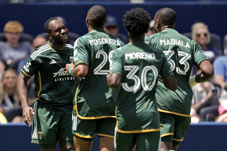 Portland Timbers forward Franck Boli, left, celebrates with teammates after scoring a goal during the first half of an MLS soccer match against Sporting Kansas City Sunday, May 28, 2023, in Kansas City, Kan. (AP Photo/Charlie Riedel)