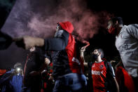 Men wearing protective face masks take part in a caravan organized by the soccer club fans of Newell's Old Boys in the hometown of Leonel Messi, in Rosario, Argentina, Thursday, Aug. 27, 2020. Fans are hoping to lure Messi home following his announcement that he wants to leave Barcelona F.C. after nearly two decades with the Spanish club. (AP Photo/Natacha Pisarenko)