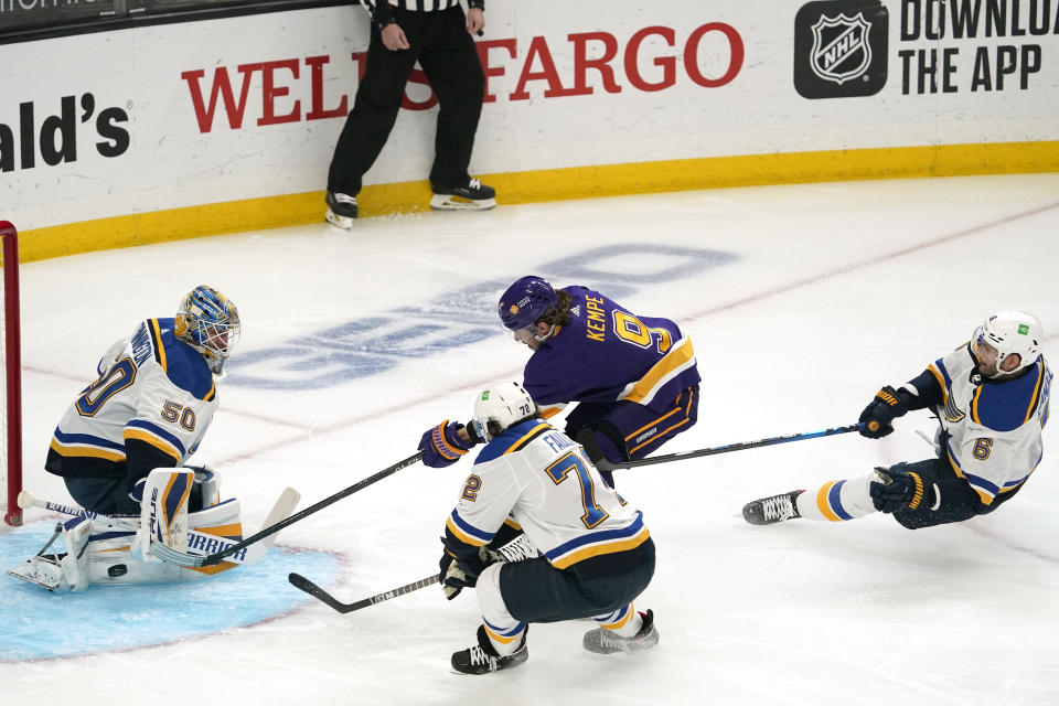 Los Angeles Kings right wing Adrian Kempe, second from right, tires to get a shot past St. Louis Blues goaltender Jordan Binnington, left, as defenseman Justin Faulk, second from left, and defenseman Marco Scandella defend during the first period of an NHL hockey game Wednesday, March 17, 2021, in Los Angeles. (AP Photo/Mark J. Terrill)