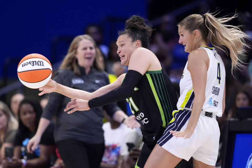 Minnesota Lynx guard Kayla McBride (21) makes a pass under defensive pressure by Dallas Wings guard Jacy Sheldon (4) in the second half of a WNBA basketball game in Arlington, Texas, Thursday, June 27, 2024. (AP Photo/Tony Gutierrez)