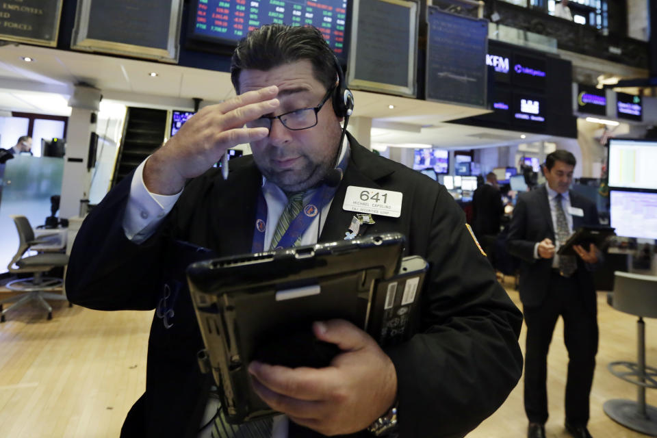 Trader Michael Capolino, left, works on the floor of the New York Stock Exchange, Monday, July 30, 2018. Stocks are off to a mixed start on Wall Street as gains in banks and energy companies are offset by losses in other sectors. (AP Photo/Richard Drew)