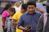 Jose Rodriguez, of Honduras, wipes his eye as he waits in line for food donated by a local church at a makeshift camp for migrants near the U.S.-Mexico border Thursday, May 13, 2021, in Reynosa, Mexico. Growing numbers of migrant families are making the heart-wrenching decision to separate from their children and send them into the U.S. alone. . (AP Photo/Gregory Bull)