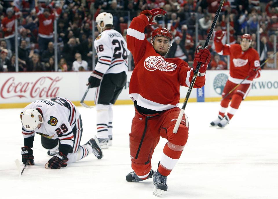 Detroit Red Wings defenseman Kyle Quincey, right, celebrates his goal against Chicago Blackhawks goalie Corey Crawford in the second period of an NHL hockey game Wednesday, Jan. 22, 2014, in Detroit. (AP Photo/Paul Sancya)