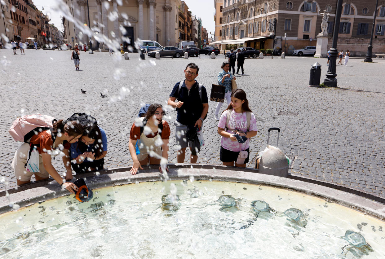 People cool off at the Piazza del Popolo, during a heatwave across Italy, as temperatures are expected to rise further in the coming days, in Rome, Italy July 18, 2023. REUTERS/Remo Casilli