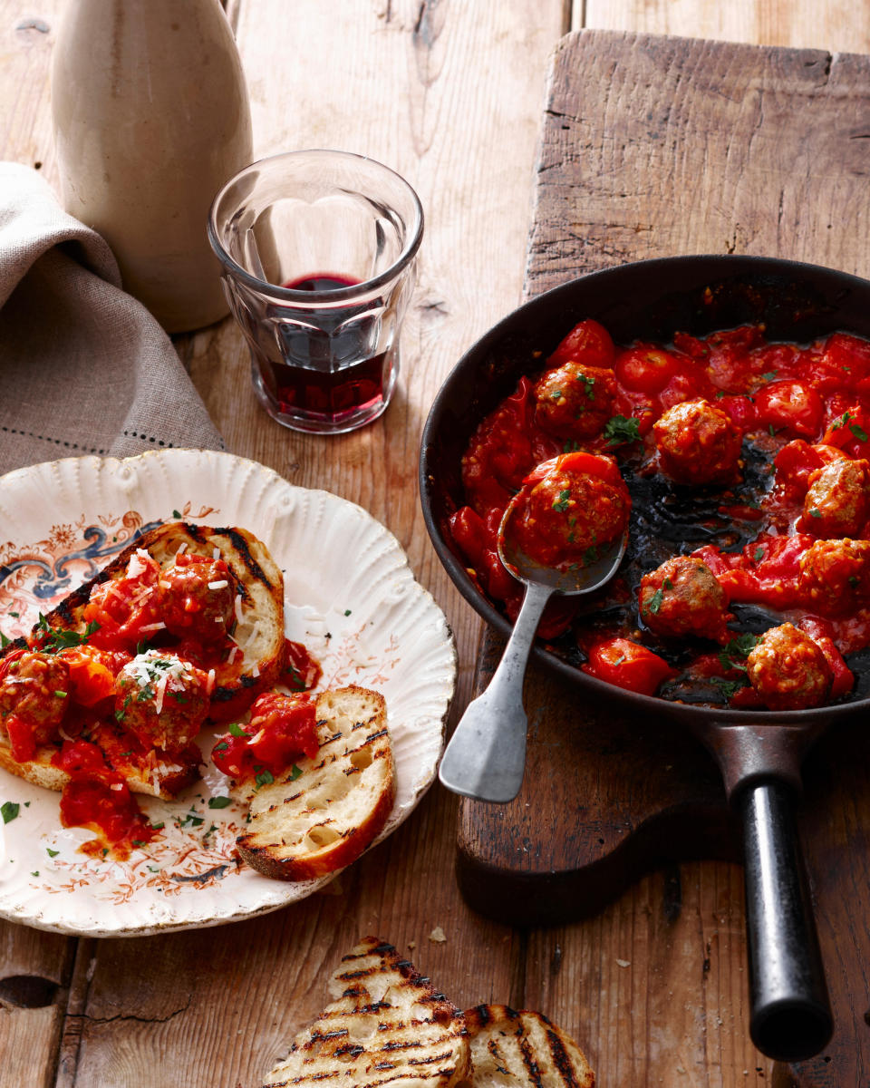 A table with meatballs, bread and wine