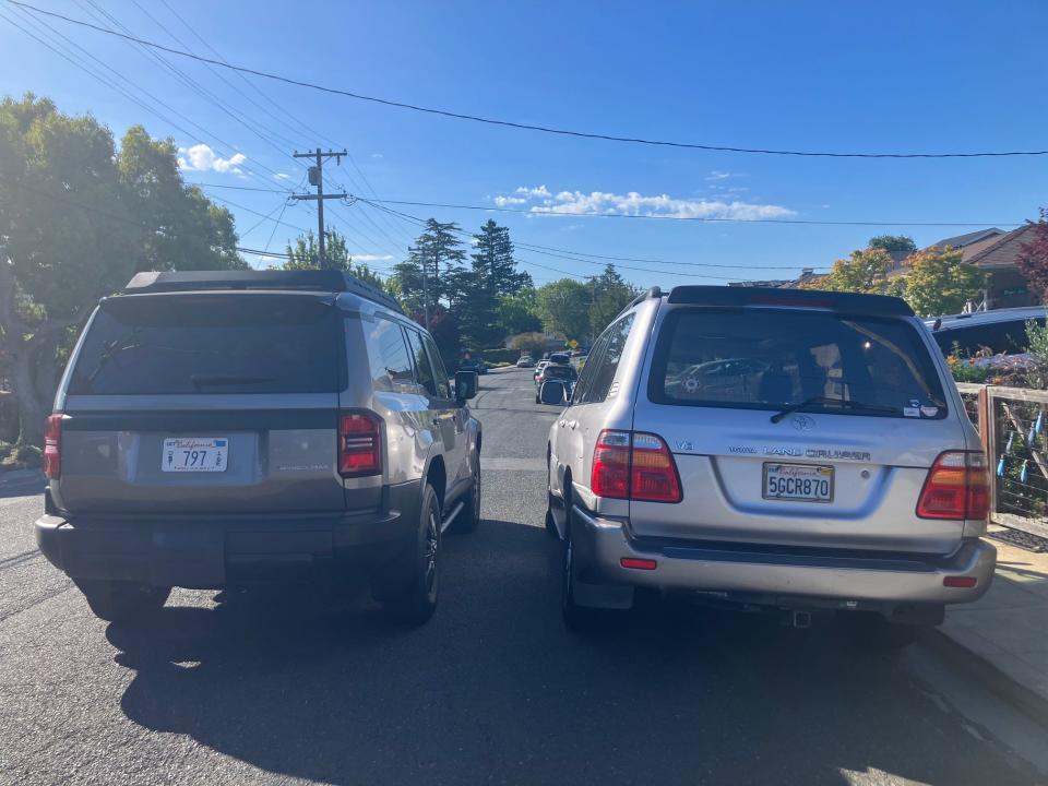 A new Toyota Land Cruiser (left) is parked on a street in Silicon Valley next to an older model.