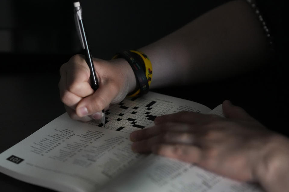 Beka Favela works a crossword puzzle at her Westmont, Ill., apartment, Tuesday, June 20, 2023. After a payment pause that has lasted more than three years, more than 40 million student loan borrowers will be on the hook for payments starting in the fall. (AP Photo/Charles Rex Arbogast)