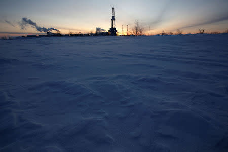 FILE PHOTO: A general view shows an drilling rig at the Lukoil company owned Imilorskoye oil field, as the sun rises, outside the West Siberian city of Kogalym, Russia, January 25, 2016. REUTERS/Sergei Karpukhin/File Photo