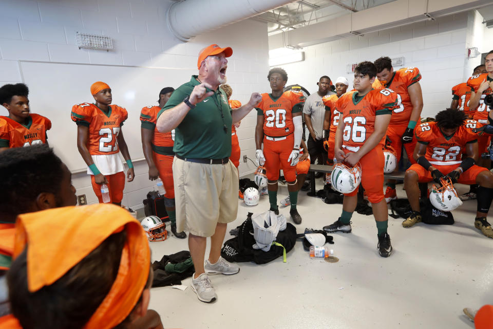 Mosley High head coach Jeremy Brown rallies his team in the locker room before the start of their football game against Pensacola, in the aftermath of Hurricane Michael in Panama City, Fla., Saturday, Oct. 20, 2018. (AP Photo/Gerald Herbert)