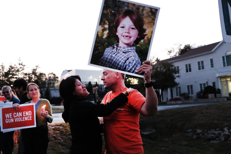 Mark Barden holds up a picture of his son Daniel, who was killed in the Sandy Hook shooting, during a vigil remembering victims of the 2017 shooting at a country music festival in Las Vegas. The vigil was organized by the Newtown Action Alliance and held outside the National Shooting Sports Foundation headquarters in Newtown. (Spencer Platt/Getty Images)