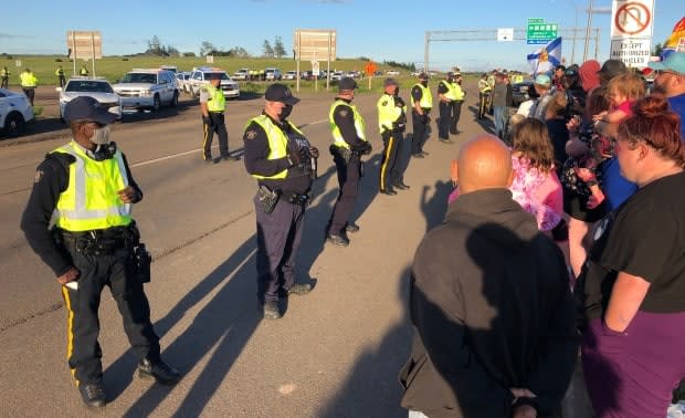 RCMP officers move dozens of protestors to the side of the Trans-Canada Highway at the Nova Scotia-New Brunswick border on the evening of June 23, 2021.  ( Jonathan Villeneuve/CBC - image credit)