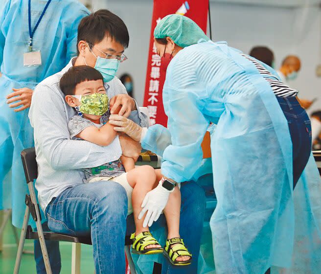新冠肺炎疫情持續蔓延，台北市兒童BNT疫苗陸續開打，在銘傳國小接種站內，1名學童聽到打針，緊張地大哭掙扎，身旁的大人忙著安撫情緒。（范揚光攝）