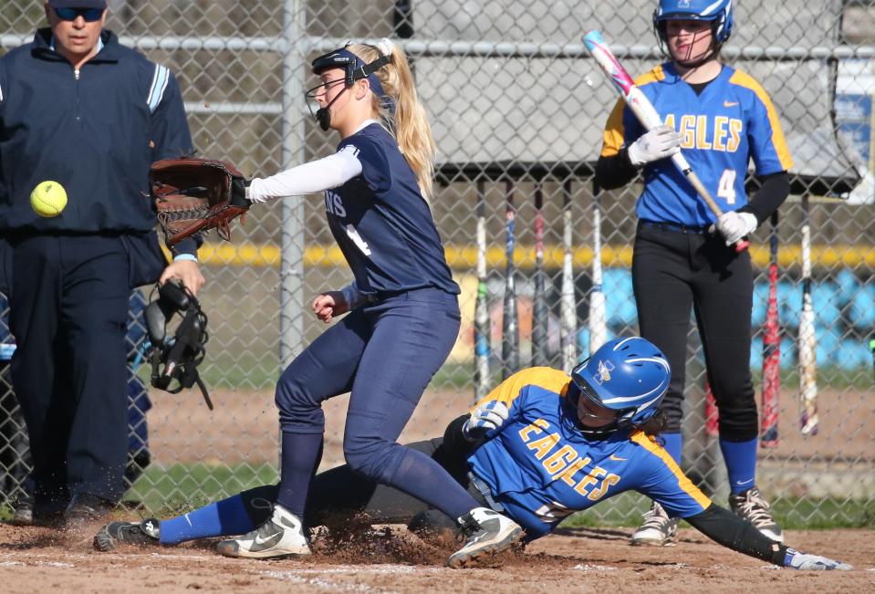 Irondequoit's Marlayna Cartagena scores on a wild pitch by Thomas' McKenzie O'Keefe, who covers home plate for the late throw from catcher Abby Suhr in the third inning.