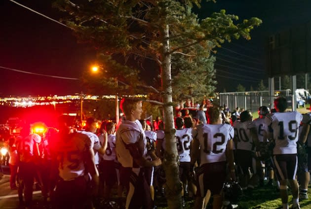 Jordan football players wait outside the East stadium after a fire suspended their game — Salt Lake Tribune