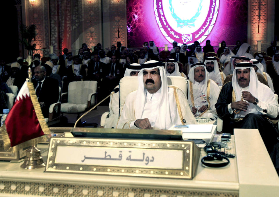 FILE - Emir of Qatar Sheik Hamad Bin Khalifa Al Thani, center, attends the opening session of the Arab League Summit in Doha, Tuesday, March 26, 2013. Sheik Hamad bin Khalifa Al Thani of Qatar was also among the rash of royals who retired in 2013, handing over power to his fourth son. (AP Photo/Ghiath Mohamad, File)