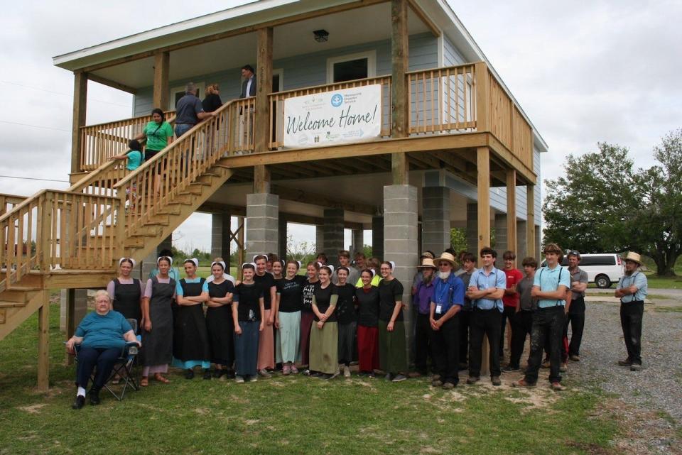 Representatives from Bayou Community Foundation, Mennonite Disaster Service and project partners welcome Linda Faye Pellegrin and family to their new home in Dulac.