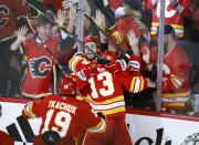 Calgary Flames forward Johnny Gaudreau (13) celebrates his goal with teammates during overtime NHL playoff hockey action against the Dallas Stars in Calgary, Alberta, Sunday, May 15, 2022. (Jeff McIntosh/The Canadian Press via AP)