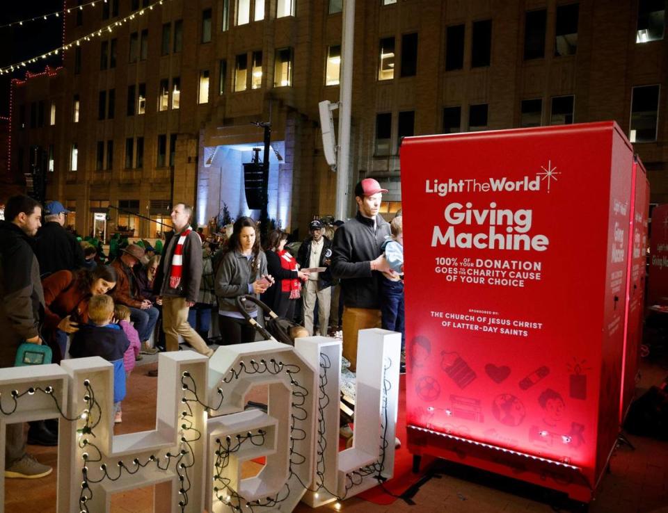 Several people gathered around and donated to the Giving Machine before Fort Worth’s lighting of the 77th Annual Fort Worth Community Christmas Tree in Sundance Square plaza. The Giving Machines offer a cashless way to give donations to regional and global nonprofits. Bob Booth/Bob Booth