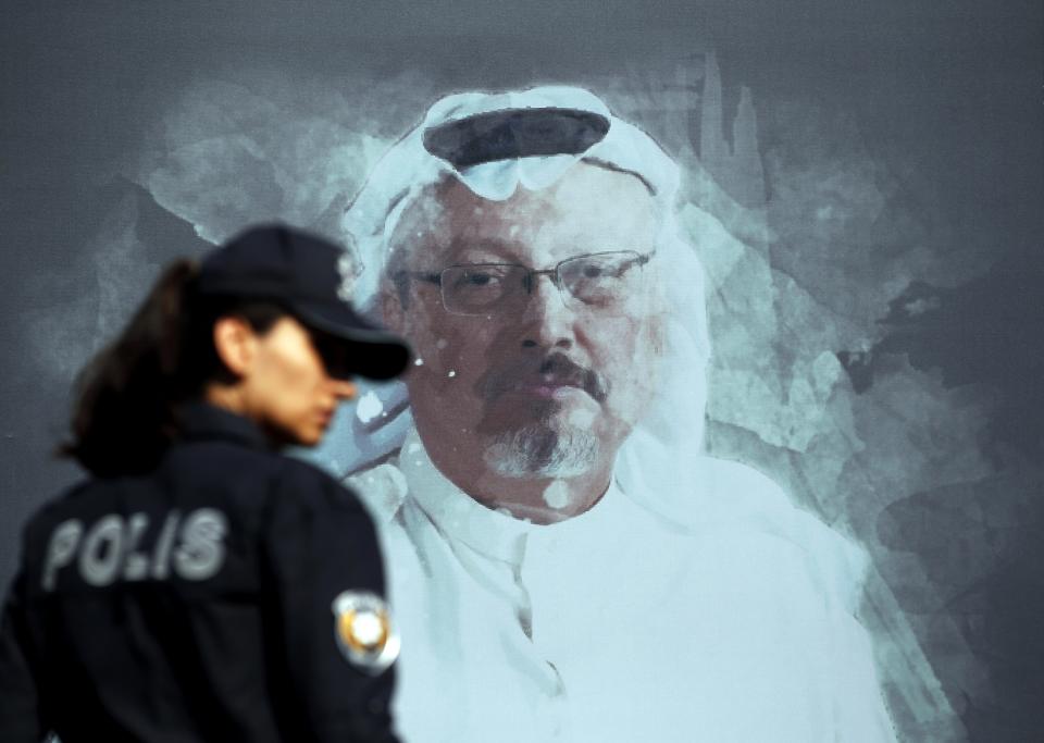 FILE - A Turkish police officer walks past a picture of slain Saudi journalist Jamal Khashoggi prior to a ceremony, near the Saudi Arabia consulate in Istanbul, Oct. 2, 2019. A Dubai-based broadcaster cut substantial portions of a recent episode of the satiric news program "Last Week Tonight with John Oliver" over references to Saudi Arabia's crown prince being implicated in the 2018 killing of Washington Post columnist Jamal Khashoggi. (AP Photo/Lefteris Pitarakis, File)