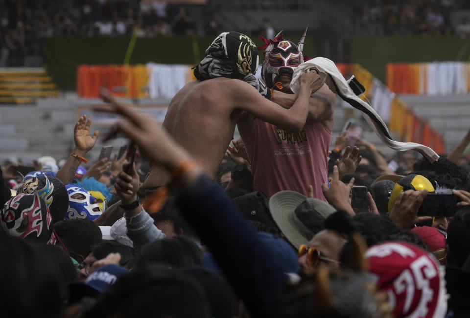 Fans de Lost Acapulco con máscaras de luchadores durante su presentación en el festival Vive Latino en la Ciudad de México el domingo 19 de marzo de 2023. (Foto AP/Fernando Llano)