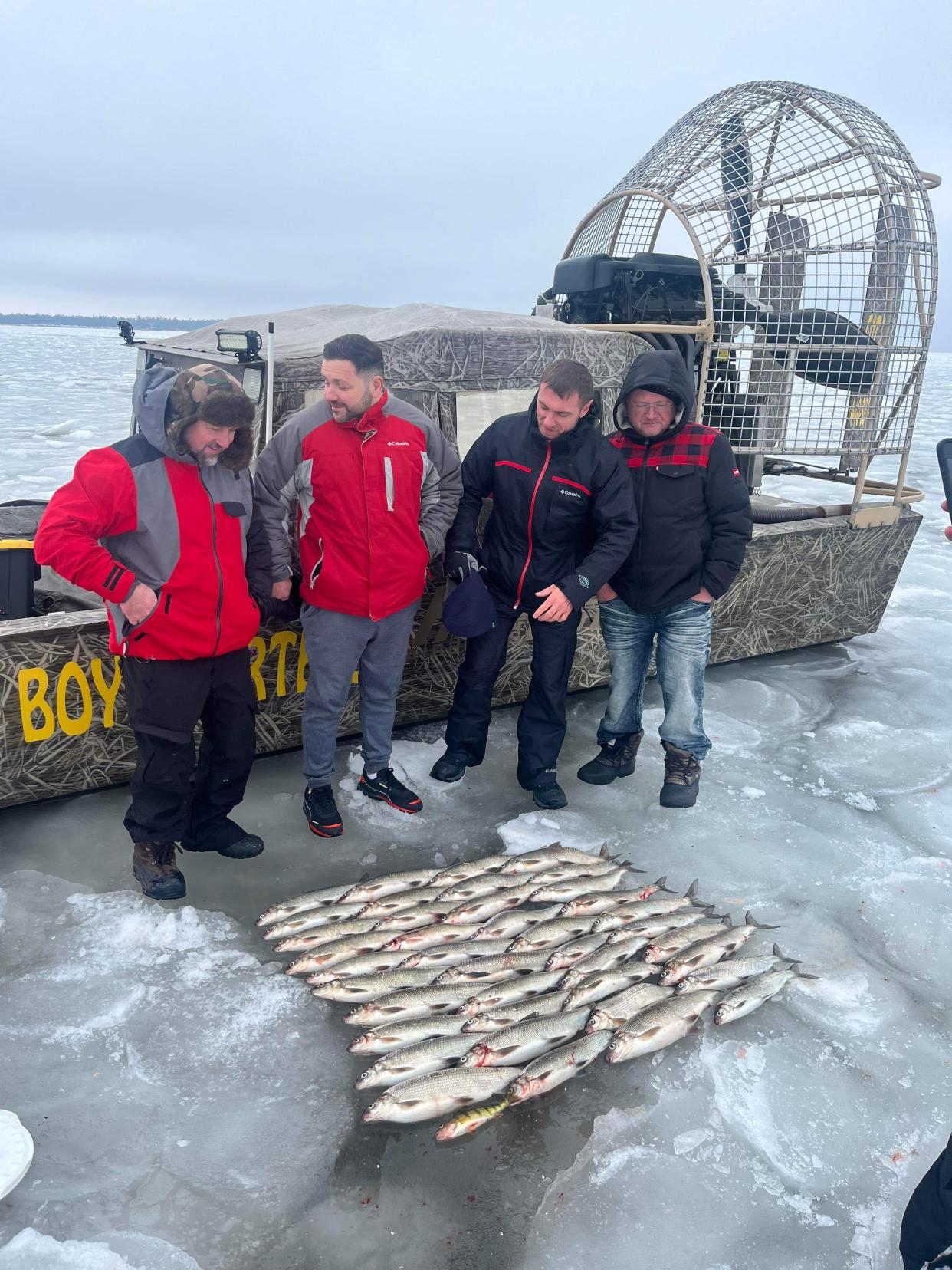 Clients of Ice Fish Green Bay pose for a photo Jan. 29 with limits of lake whitefish on the ice of Green Bay.